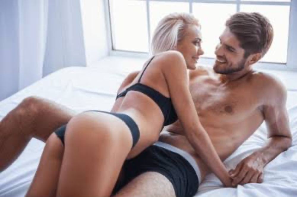 Couple in bed showing the real-life result of consistent sex live chat on HotChatLive
